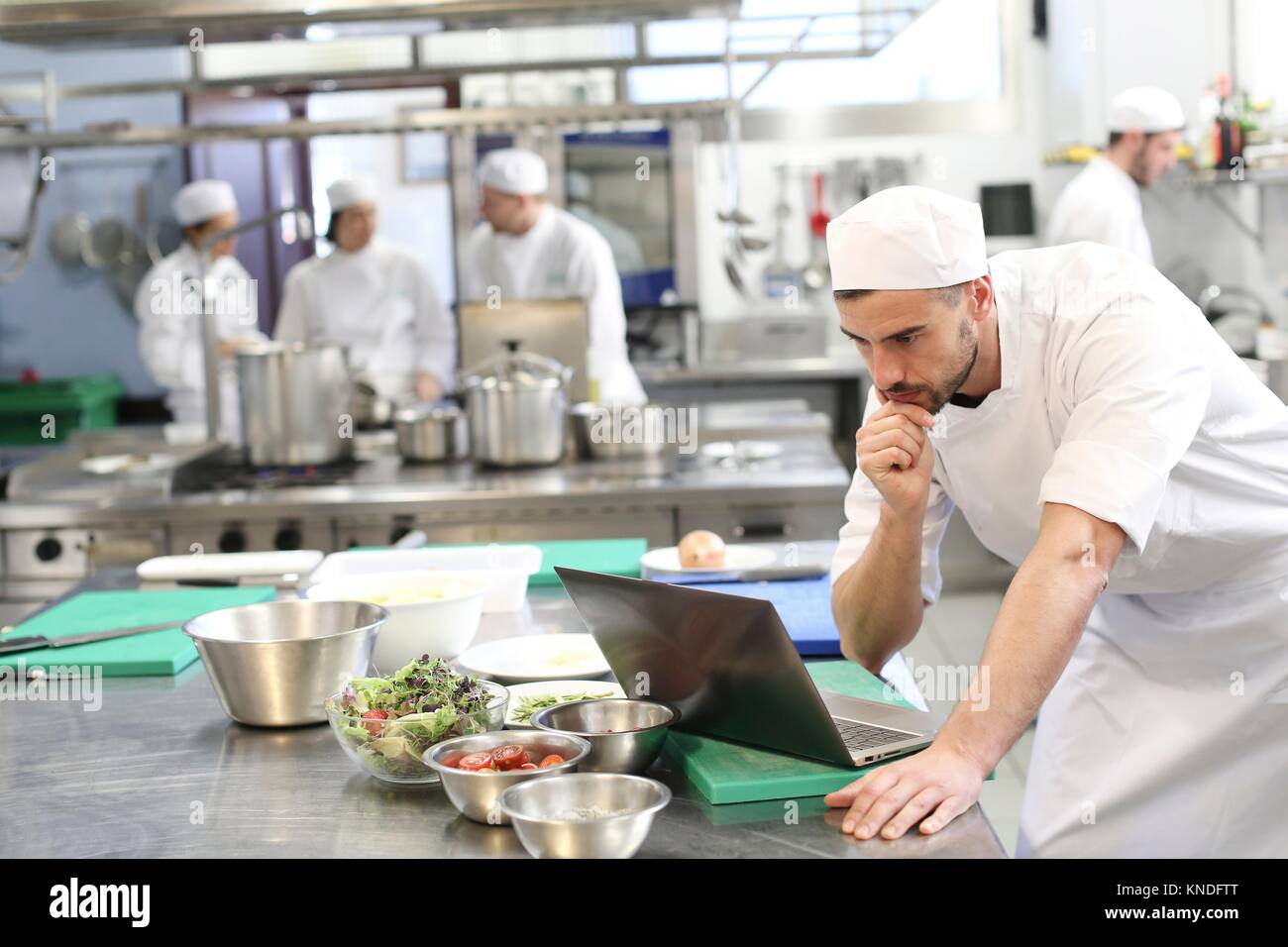 Koch mit Laptop, Kochen in der Küche der Schule, Küche