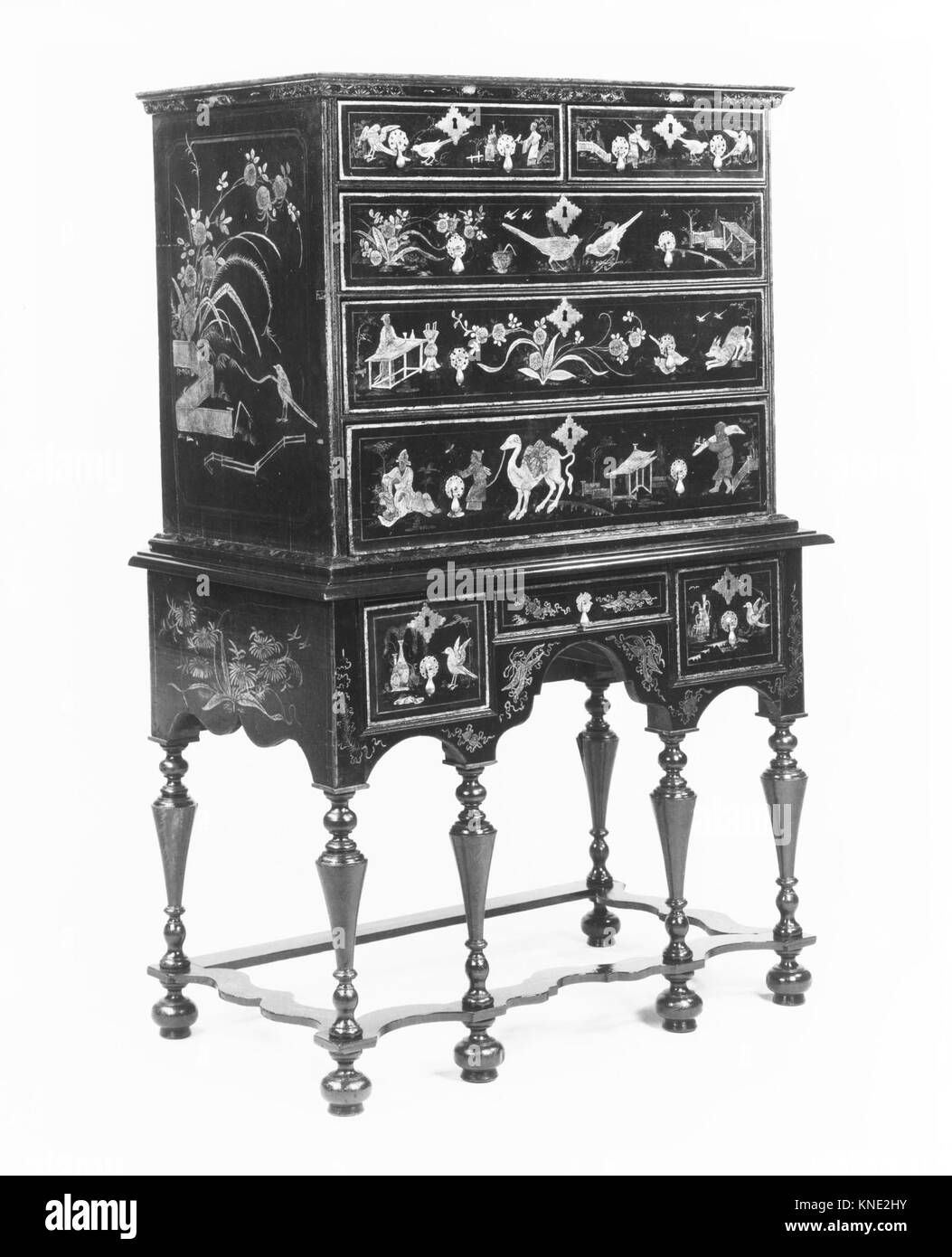 Eine hohe Kommode zeigt edles Möbeldesign, historische Handwerkskunst und die Verwendung von Holz für funktionale Aufbewahrungs- und Dekorationszwecke, die historische Inneneinrichtung widerspiegelt. Stockfoto