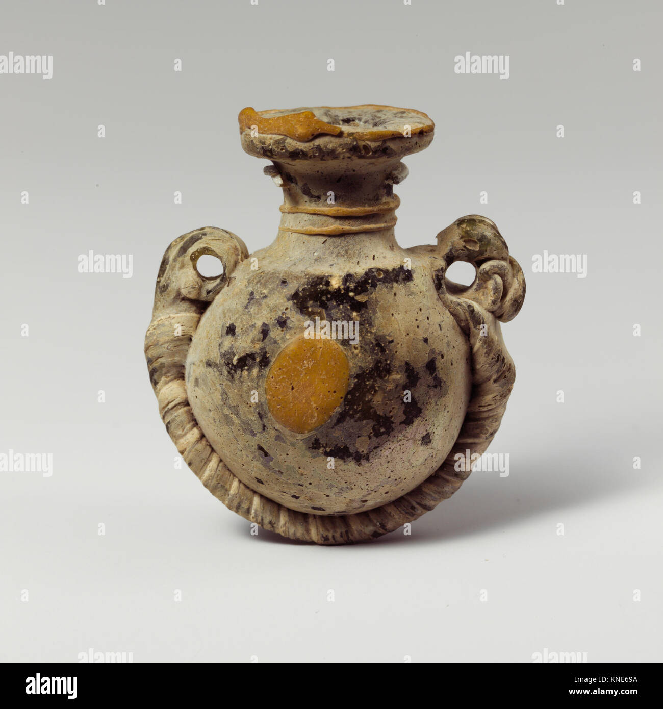 Eine griechische Lentoid-Aryballos (Parfümflasche) aus dem 4. Bis 3. Jahrhundert v. Chr., die komplexe Glaskunst und antike griechische Handwerkskunst zeigt. Stockfoto