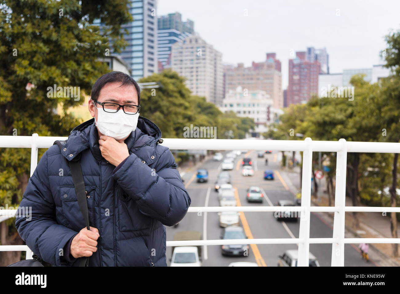 Smog in der Stadt. Männer in der medizinischen Maske mit Halsschmerzen Stockfoto