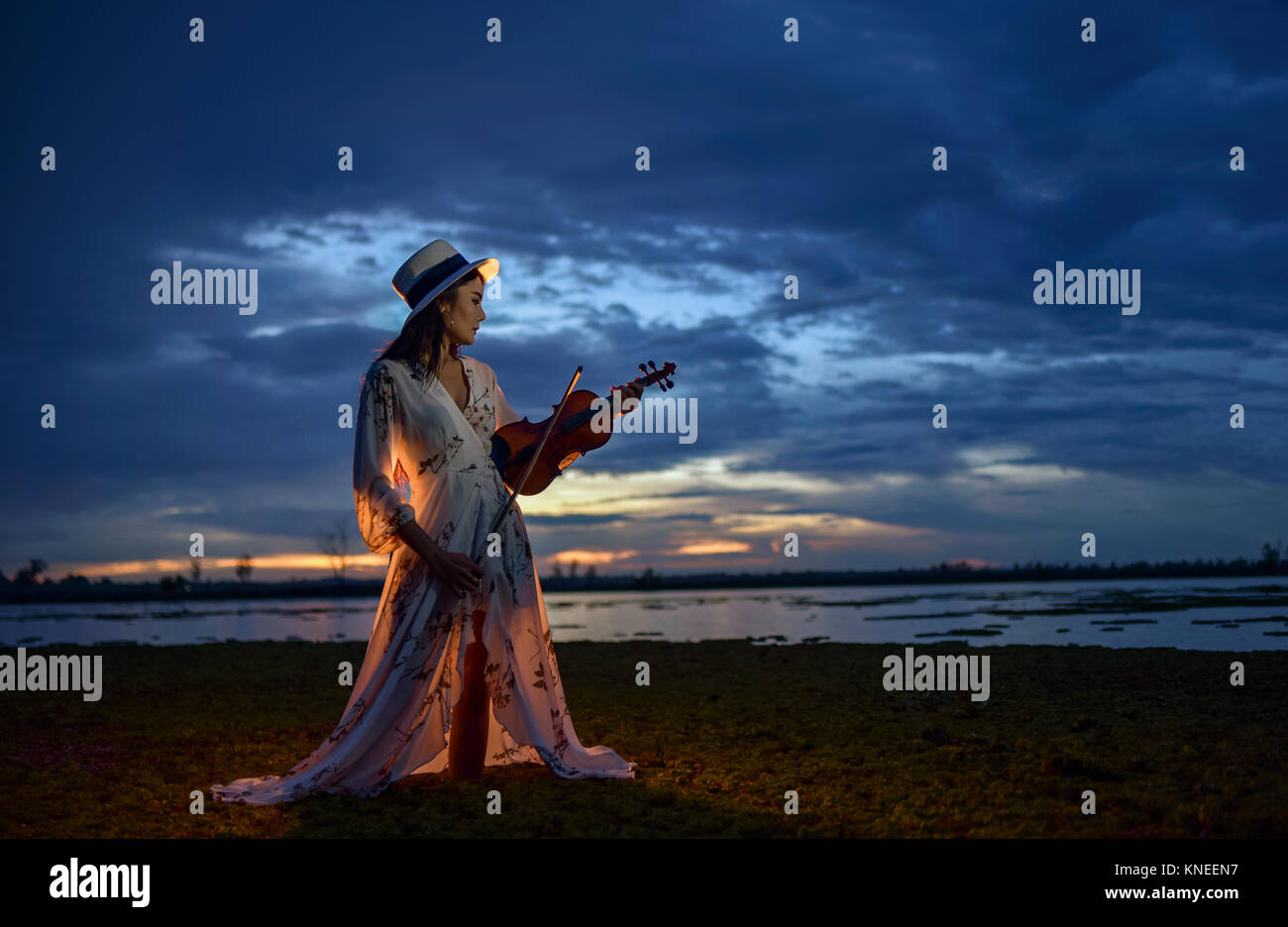 Frau am Strand bei Sonnenuntergang Spielen der Violine Stockfoto