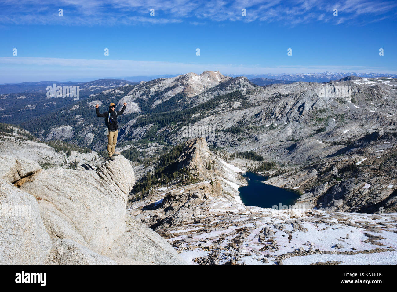 Mann auf Alta Peak mit erhobenen Armen, Pear See und Riesen Sequoia Wald in der Ferne, Kalifornien, USA Stockfoto