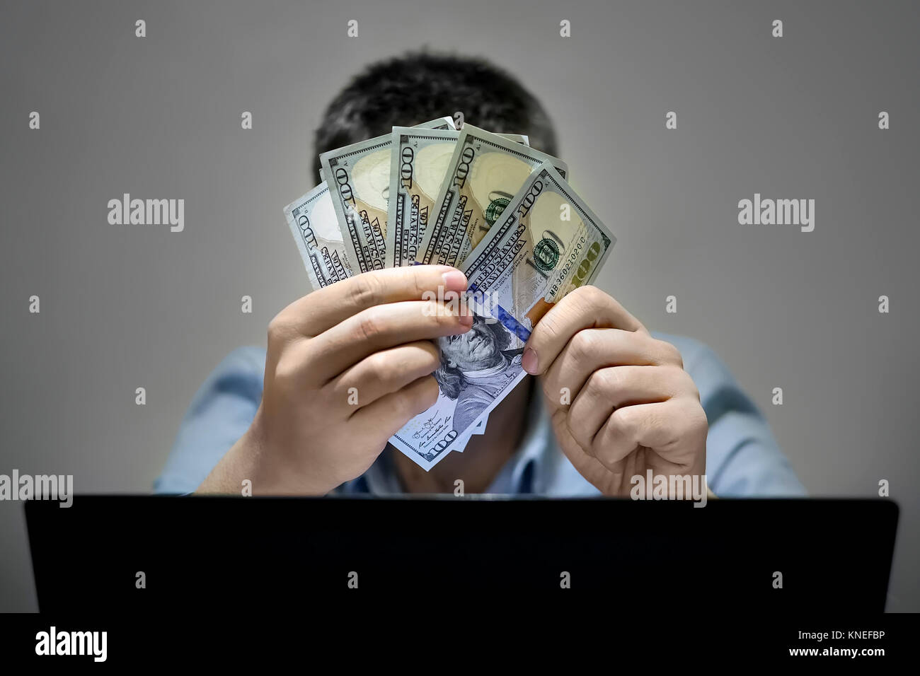 Nahaufnahmen der Hände shopping online mit Laptop halten US-Dollar. Das Ergebnis. Freelancer glaubt, dass sein Gehalt. Einfach Geld. Arbeit im Internet Stockfoto