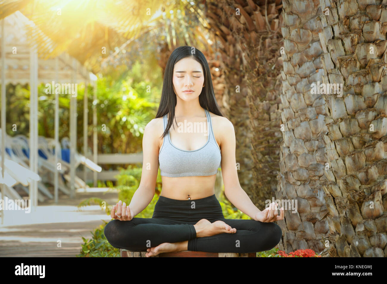 Frau sitzt in einem Park Yoga Stockfoto