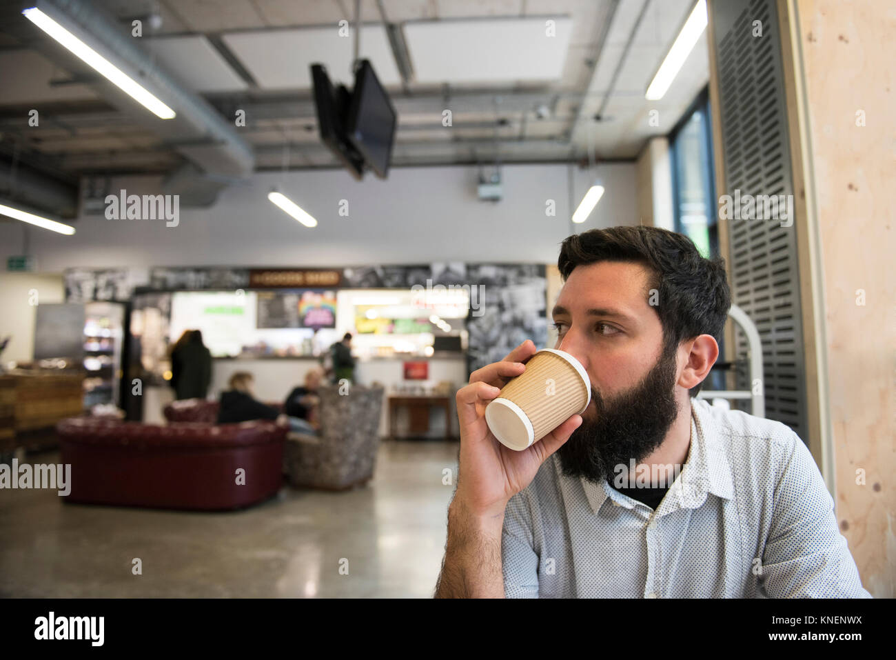 Mann trinken aus Einweg Becher in Coffee Shop Stockfoto