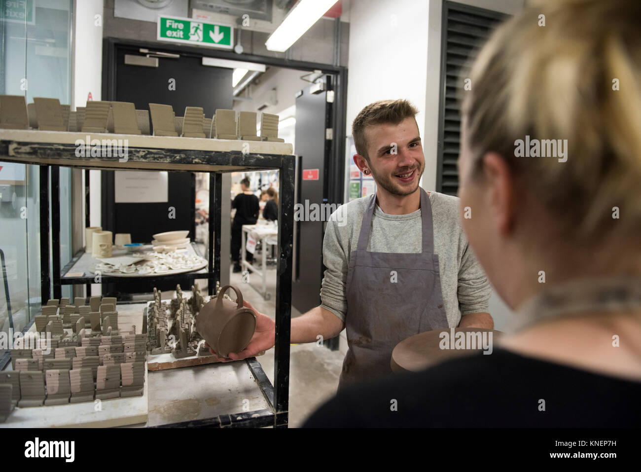 Töpfer in art studio Diskussion Töpferei im Regal Stockfoto