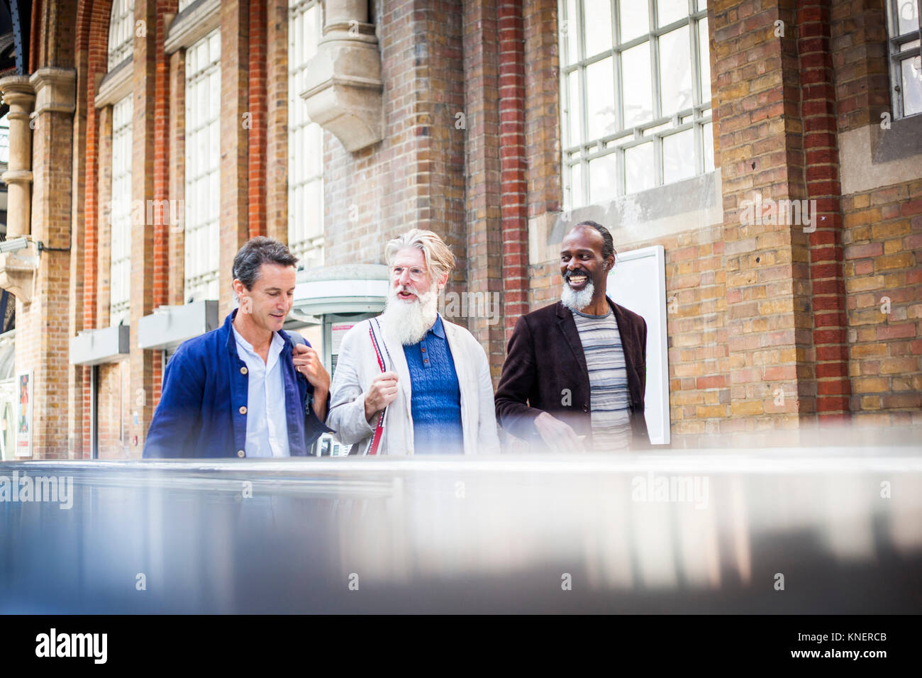 Drei reife Männer am Bahnhof, zusammen gehen Stockfoto
