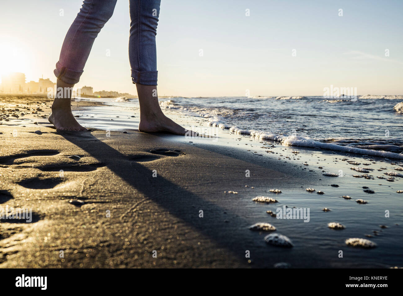 Beine von barfüßigen Frau, im Water's Edge am Strand, Riccione, Emilia-Romagna, Italien Stockfoto
