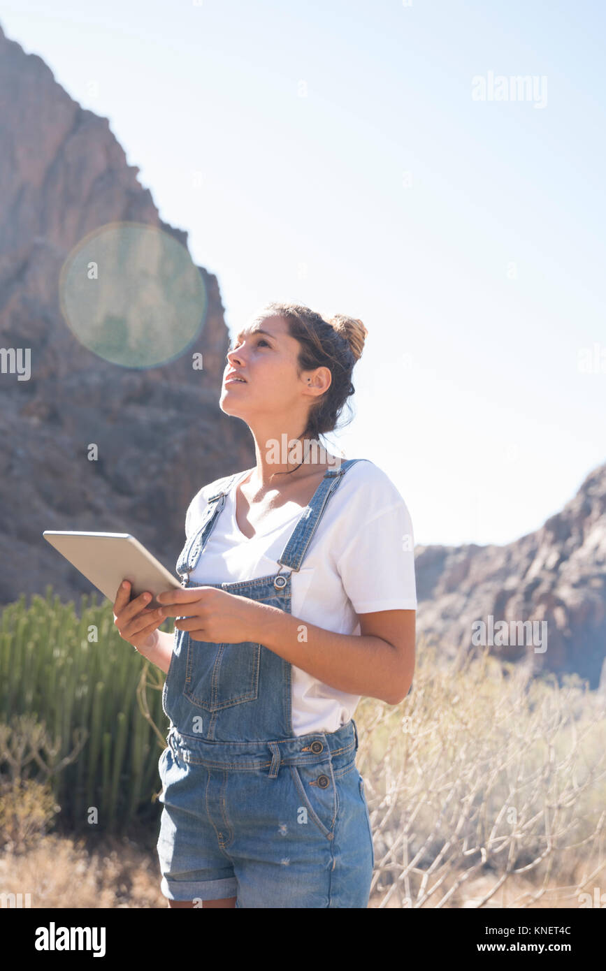 Junge weibliche Wanderer mit digitalen Tablet von sonnendurchfluteten Tal, Las Palmas, Kanarische Inseln, Spanien Stockfoto