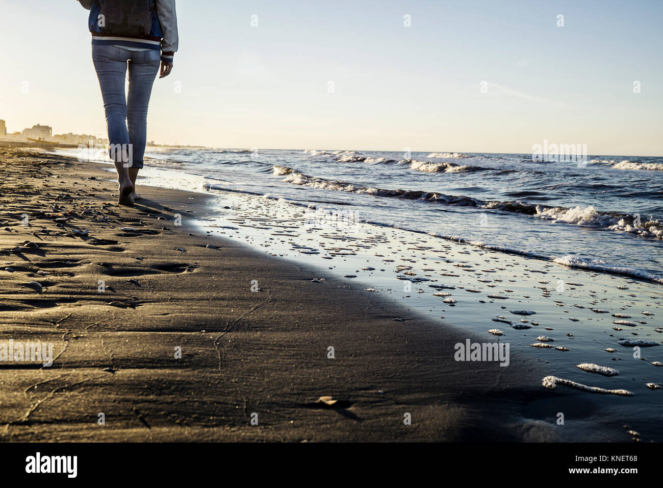 Taille nach unten an der barfüßigen Frau entlang der Wasserkante am Strand, Riccione, Emilia-Romagna, Italien bummeln Stockfoto