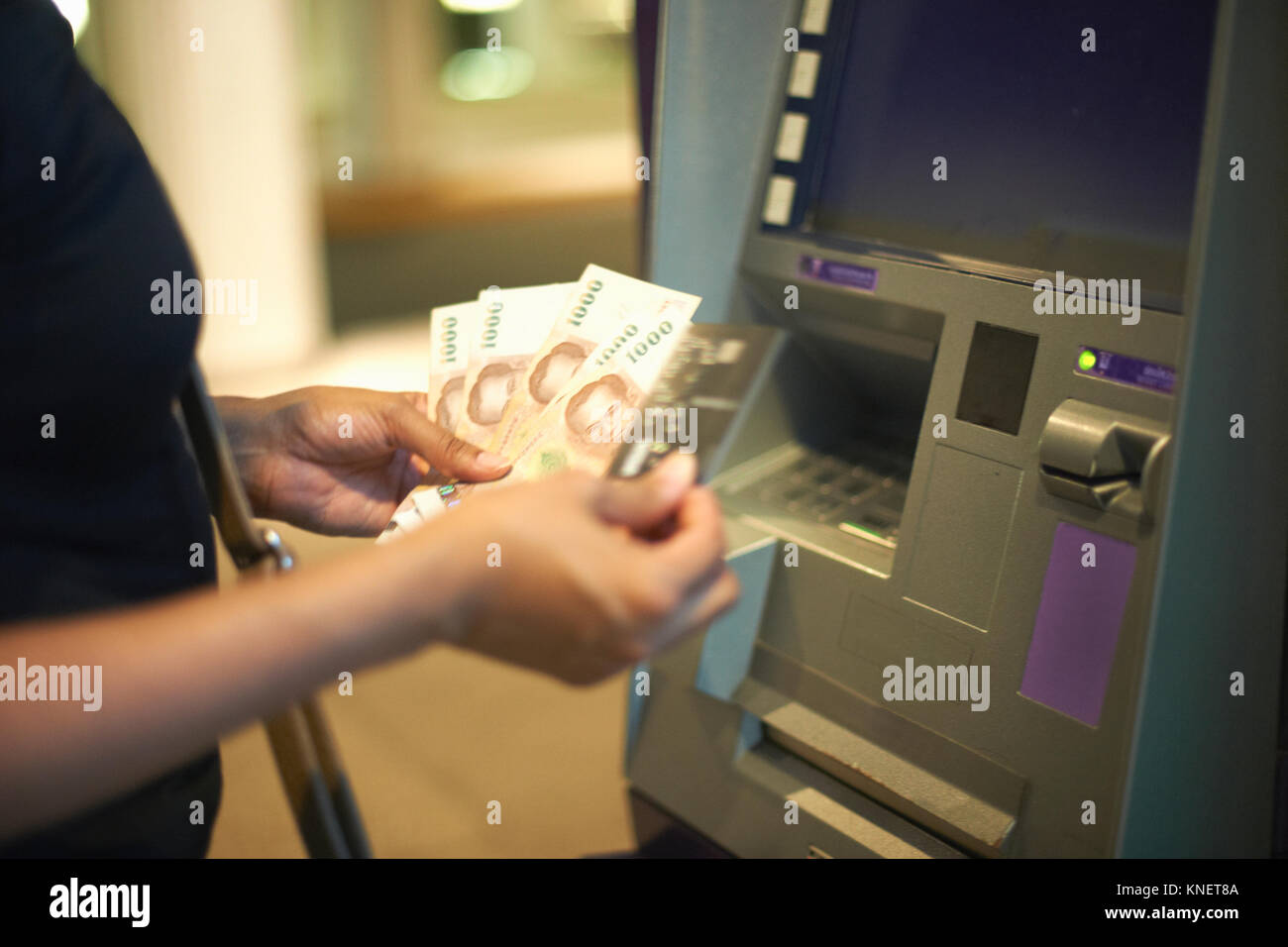 7/8-Ansicht von Frau Geld Abheben aus Geldautomaten Stockfoto
