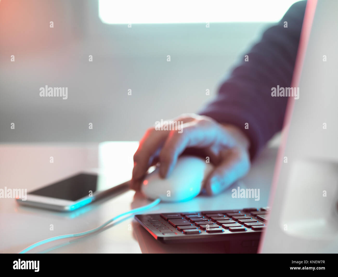 Computer Hacker am Laptop mit Handy Stockfoto
