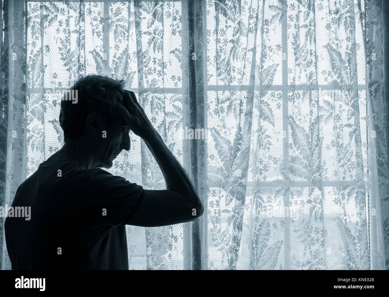Reifer Mann mit der Hand auf den Kopf in der Nähe der Fenster. Konzept Bild für Depressionen, männlichen Depression, psychische Gesundheit, männliche Selbstmord... Stockfoto