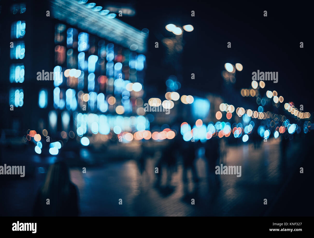 Verschwommen Stadt bei Nacht. Bokeh. Schöne Zusammenfassung Hintergrund mit Defokussierten Gebäude, Autos, City Lights, Leute. Bunte bokeh Hintergrund mit städtischen Stockfoto