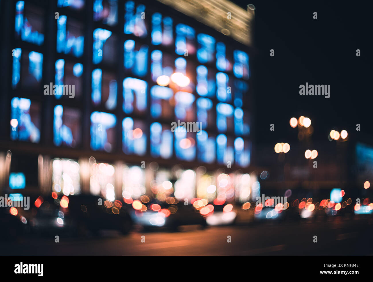 Verschwommen Stadt bei Nacht. Bokeh. Schöne Zusammenfassung Hintergrund mit Defokussierten Gebäude, Autos, City Lights, Leute. Bunte bokeh Hintergrund mit städtischen Stockfoto
