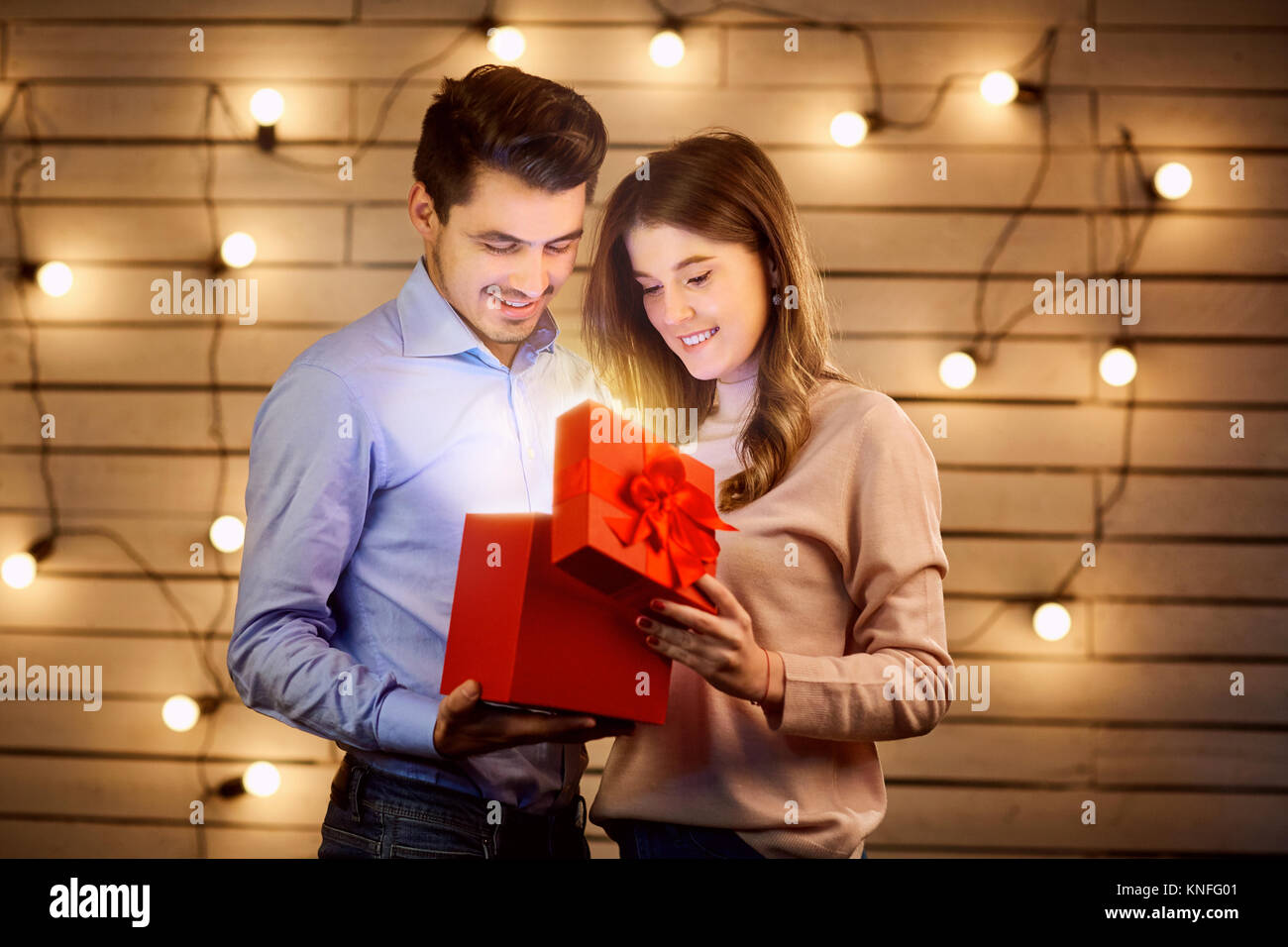 Junges Paar in einer Box mit einem Geschenk suchen. Stockfoto