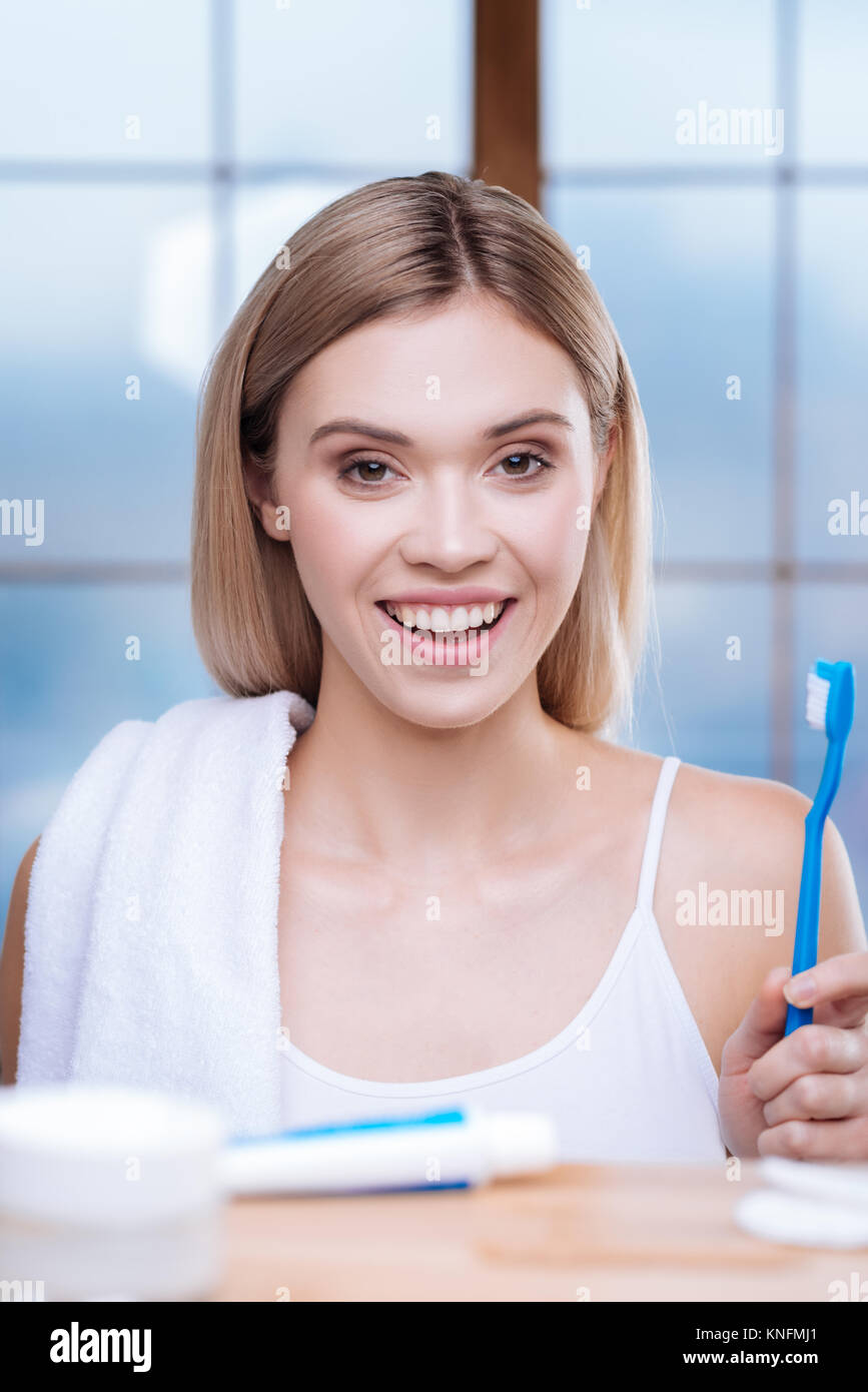 Optimistische junge Frau mit einer Zahnbürste posing Stockfoto