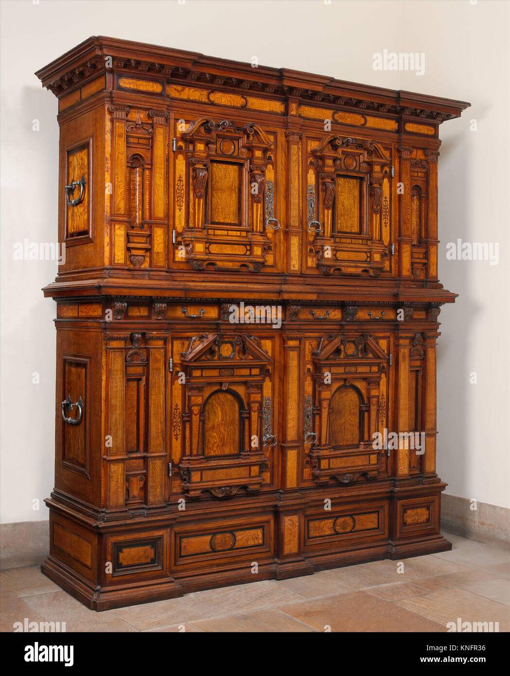 Dieser Nürnberger Fassadenschrank aus dem frühen 17. Jahrhundert ist ein deutscher Schrank aus Kiefer, Eiche und Nussbaum mit Intarsien und schmiedeeisernen Akzenten, die die Handwerkskunst der Epoche hervorheben. Stockfoto