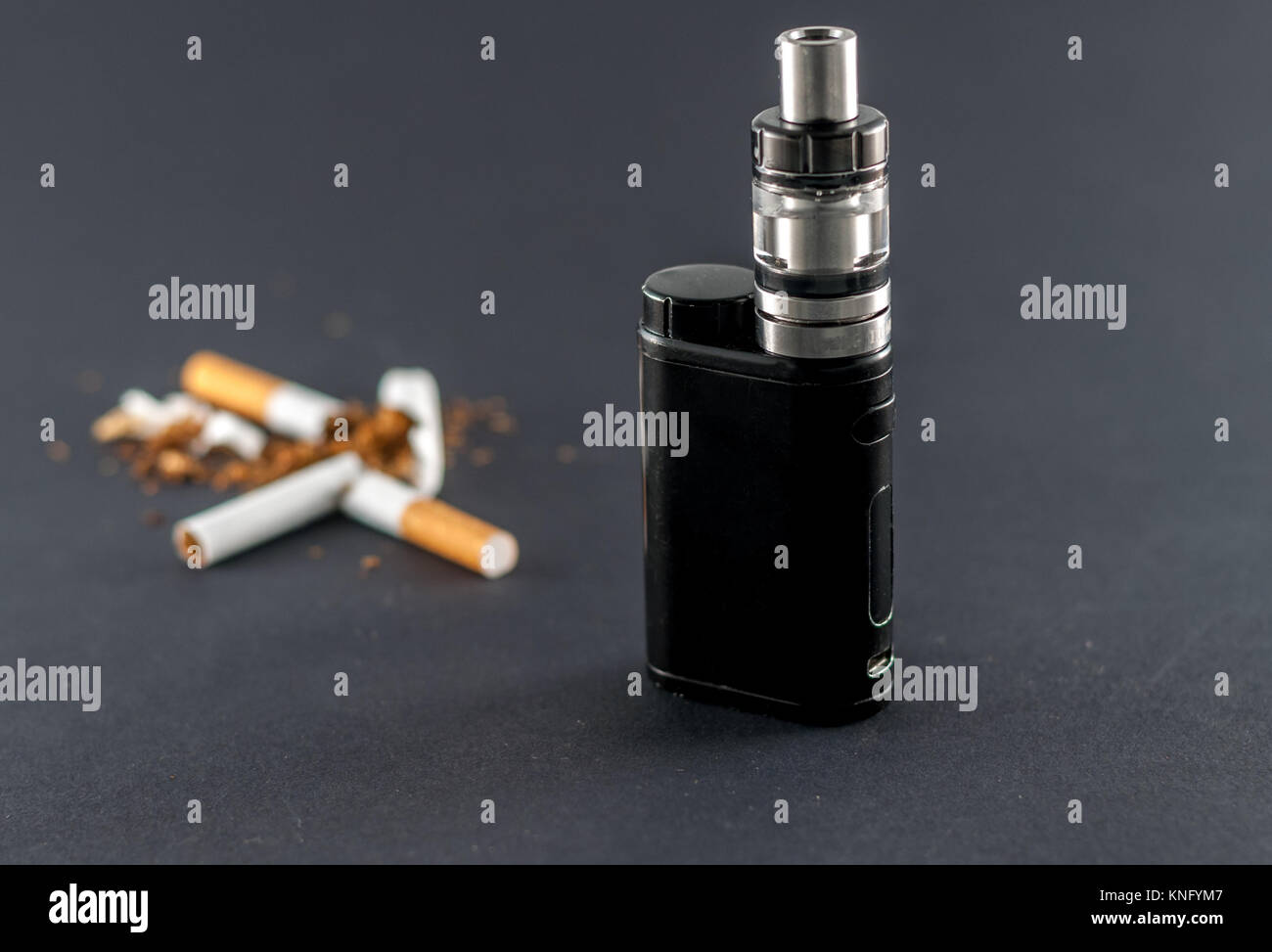 Nahaufnahme der e-Zigarette und gebrochene Zigaretten auf dunklem Hintergrund Stockfoto