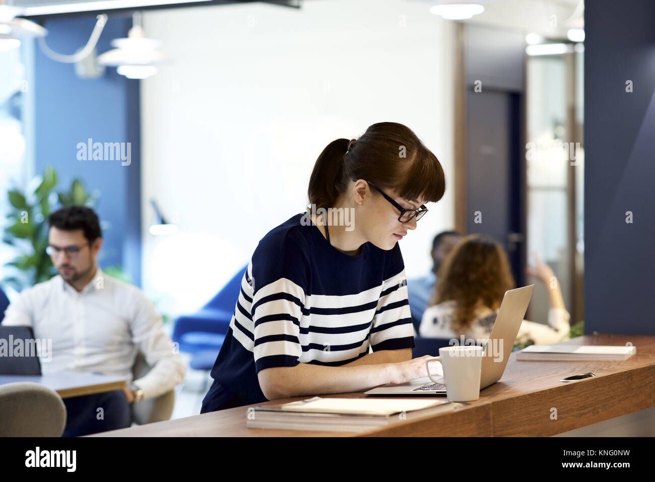 Junge weibliche Unternehmer Geschäftsfrau, tragen, Brille, der an einem Notebook arbeitet in einem modernen Büro Stockfoto