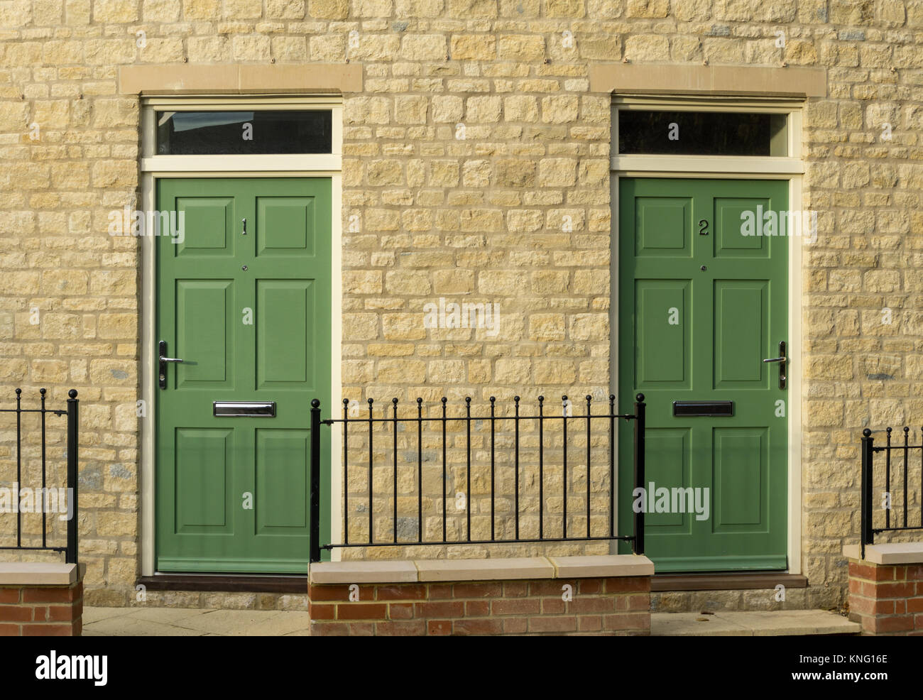 Ein paar passenden grünen Türen auf ein neues Gehäuse Entwicklung, direkt an der High Street, in der Stadt von Towcester, Großbritannien Stockfoto