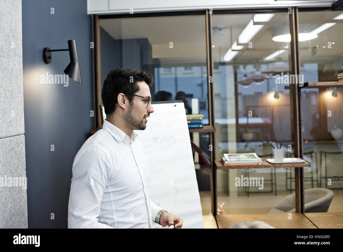 Kaukasische Geschäftsmann stehend in einem Büro Besprechungsraum Präsentation vor einer Gruppe von Kolleginnen und Kollegen vor der Kamera Stockfoto