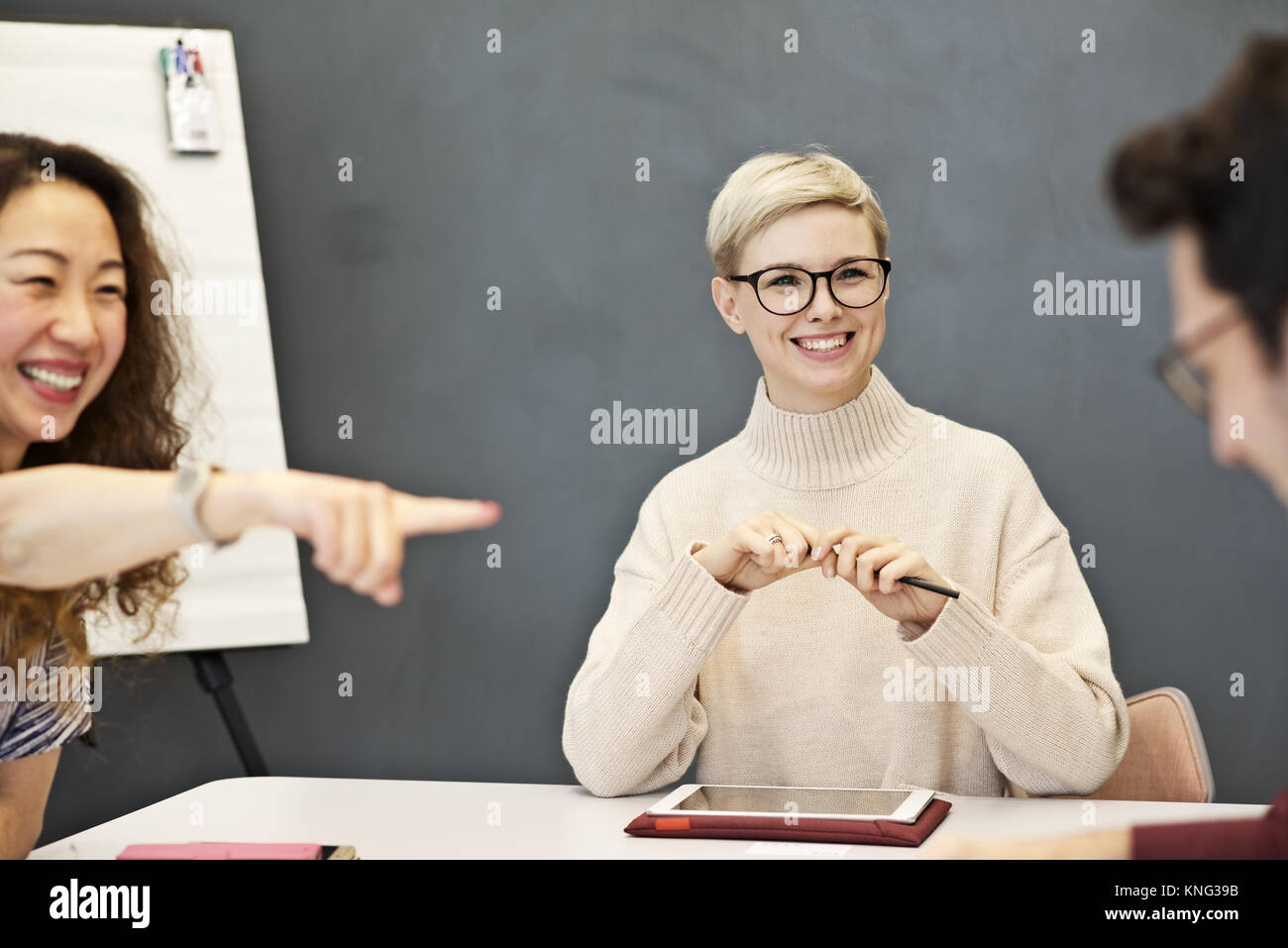 Junge professionelle Geschäftsfrau in Diskussion mit Kollegen in einem Sitzungssaal Sitzung in einem modernen Büro eingeschaltet Stockfoto