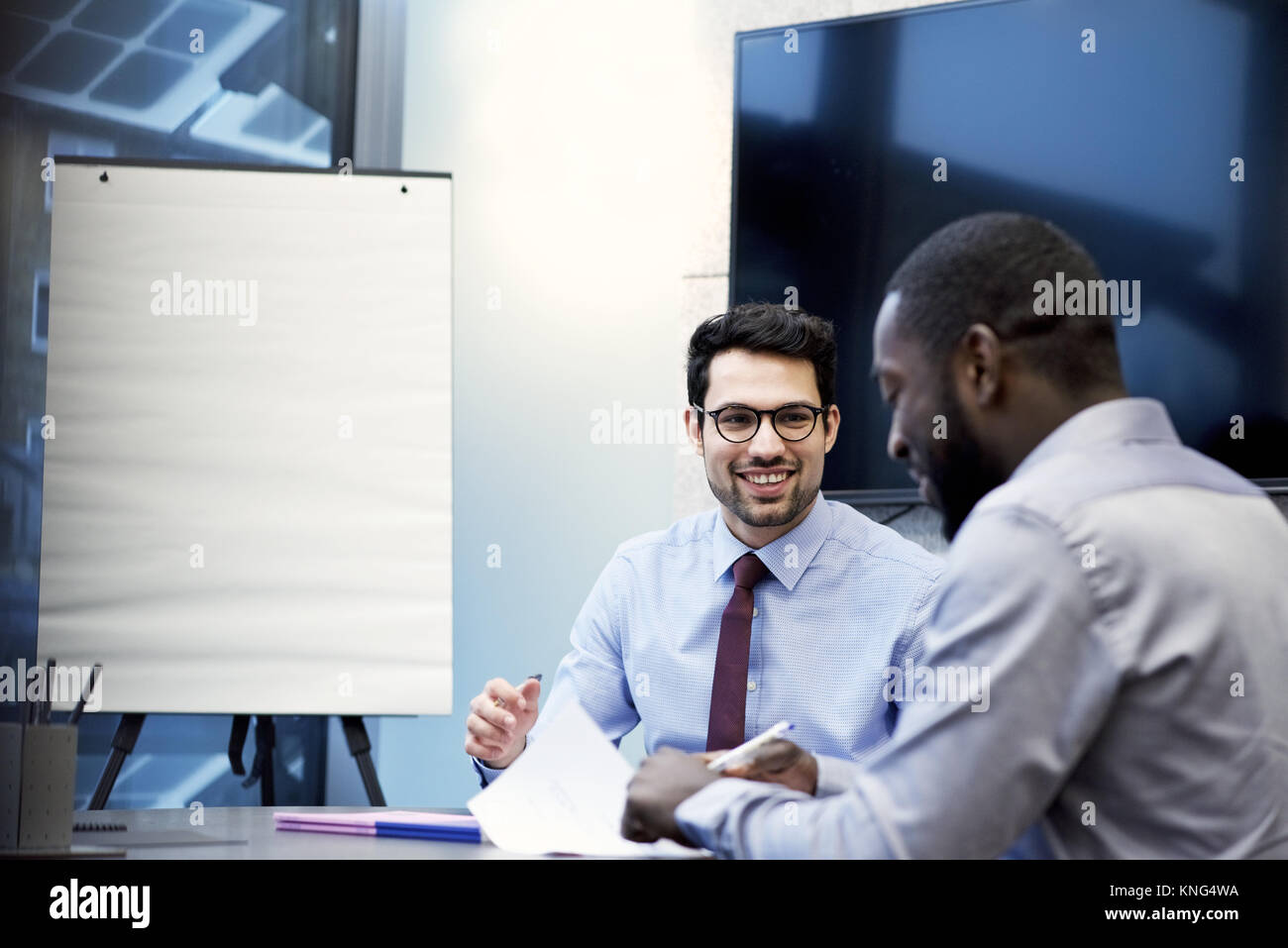 Latino Geschäftsmann und ein schwarzer Geschäftsmann in einer Konferenz in einem modernen Büro Stockfoto