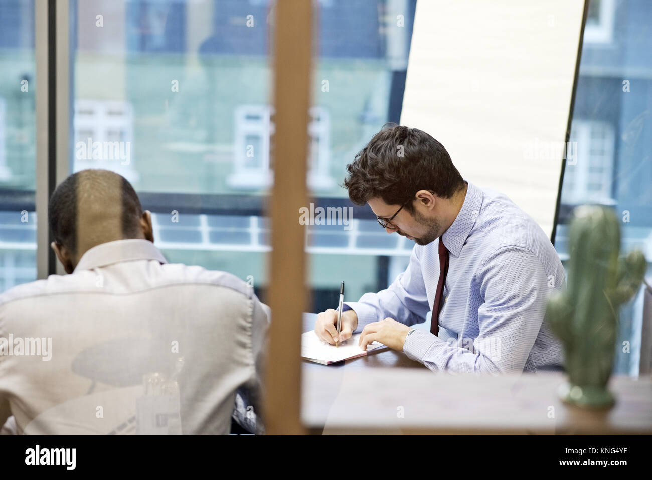 Latino Geschäftsmann und ein schwarzer Geschäftsmann in einer Konferenz in einem modernen Büro Stockfoto