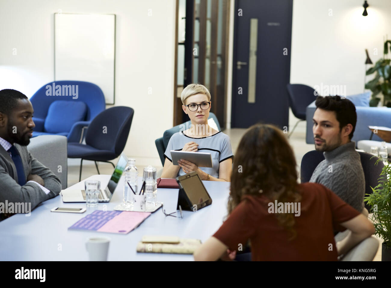 Weibliche Business Leader mit einem mobilen Gerät leiten ein Team in einem modernen Büro Stockfoto