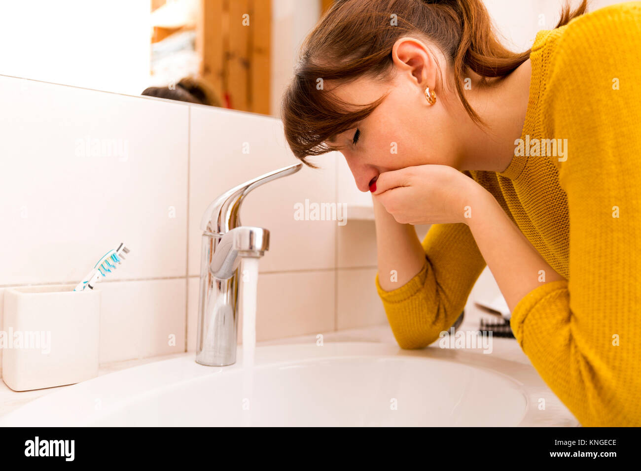 Junge erbrechen Frau in der Nähe von Waschbecken im Badezimmer Stockfoto