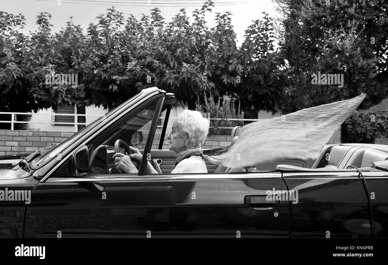Alte Frau, die ein Cabrio Stockfoto