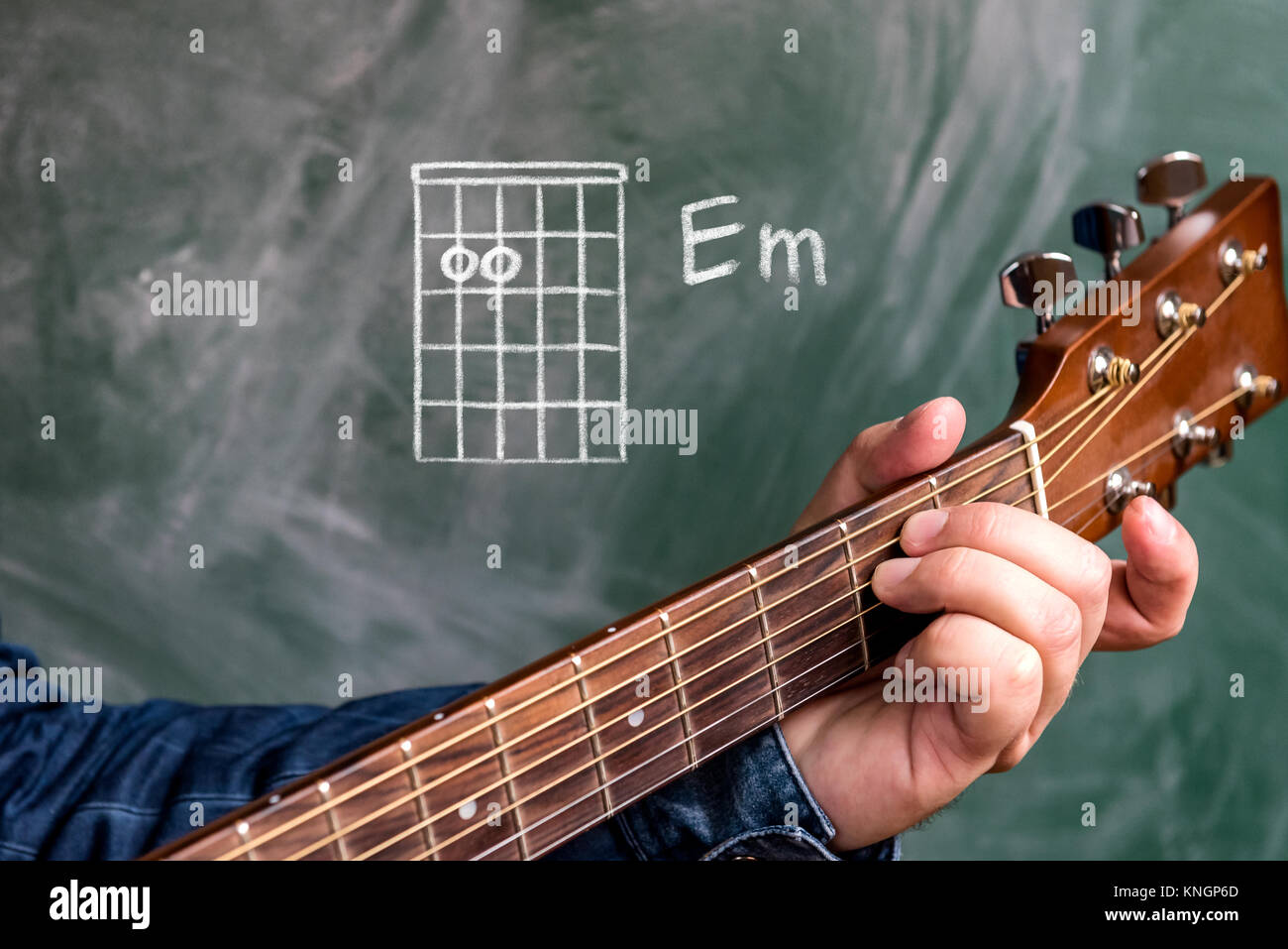 Mann in ein blaues Jeanshemd mit Gitarre Akkorde auf einer Tafel angezeigt, Akkord  E-Moll Stockfotografie - Alamy