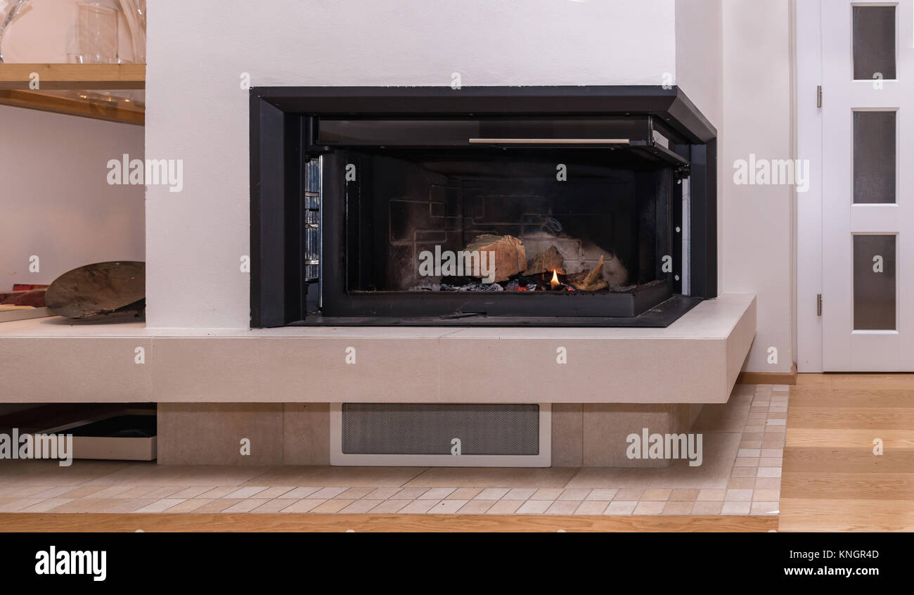 Kamin in einem modernen Haus. Das Verbrennen von Holz in den Kamin. Nahaufnahme auf die Füße. Winter- und Weihnachtsferien Konzept. Stockfoto