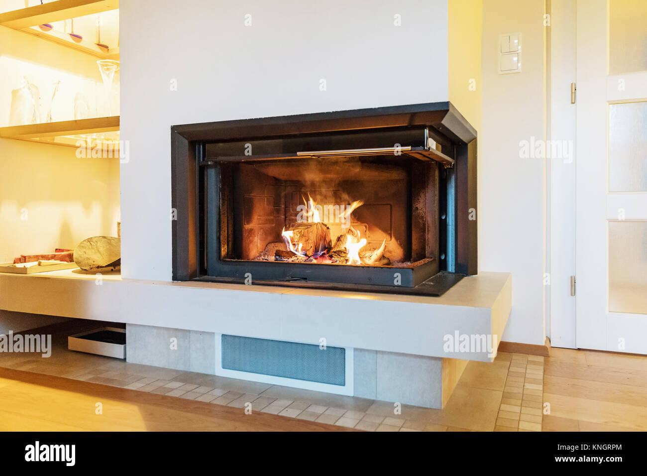 Kamin in einem modernen Haus. Das Verbrennen von Holz in den Kamin. Nahaufnahme auf die Füße. Winter- und Weihnachtsferien Konzept. Stockfoto