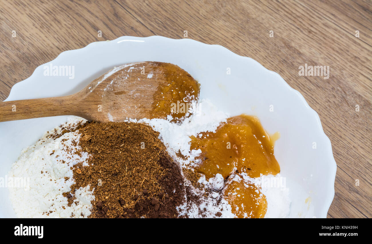 Stapel von Zutaten für die Zubereitung von süßen Weihnachten Lebkuchen. Detail von Mehl, Zucker, Honig und Gewürzen in Weiß dekorative Schale auf einem Holz Hintergrund. Stockfoto