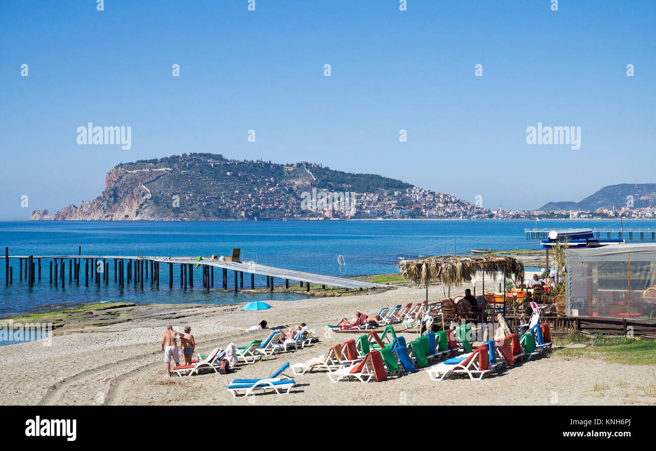Beach Bar mit sunbedsat an der Oba-Strand entfernt, hinter dem Castle Hill, Alanya, Türkische Riviera, Türkei Stockfoto