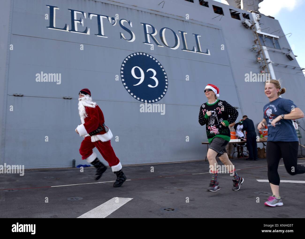 Ein Weihnachtsmann Imitator rennen US-Segler während ein Rentier Laufen am Weihnachtstag an Bord der USN San Antonio-Klasse amphibious Transport dock Schiff USS Somerset am 25. Dezember 2016 in das Arabische Meer. (Foto von MCS 2 Jakob I. Allison über Planetpix) Stockfoto