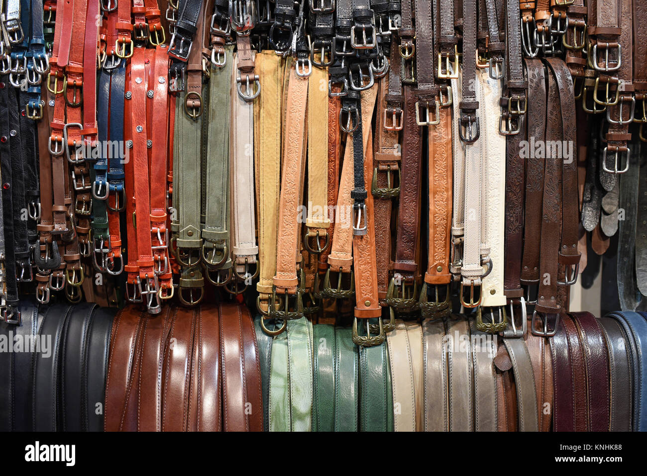 Großes Sortiment an Leder Gürtel auf Schienen zum Verkauf hing in einem Geschäft in unterschiedlichen Farben in einem full frame Hintergrund anzeigen Stockfoto