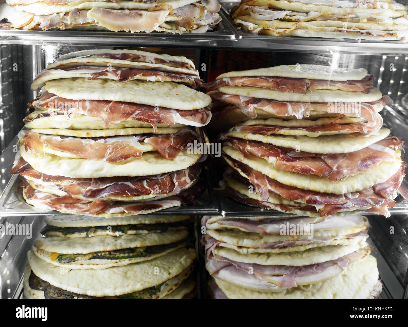 Essen im Kühlschrank mit Glasfront in einem Restaurant oder Café mit fertige Wurst Sandwiches auf Fladenbrot gestapelt Stockfoto