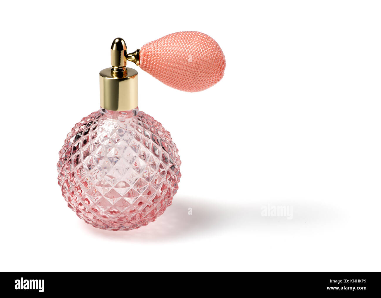 Rosa geschliffenes Glas Parfüm Flasche mit Zerstäuber mit Gewebe aus Spinnstoffen, die die Glühlampe über einen weißen Hintergrund mit Kopie Raum Stockfoto