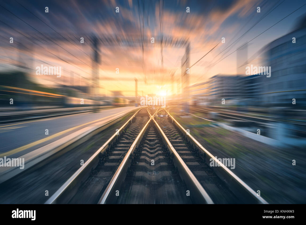 Bahnhof mit Motion blur Effekt. Verschwommen Eisenbahn. Industrielle konzeptuelle Landschaft mit unscharfen Bahnhof, Gebäude, blauer Himmel mit Colo Stockfoto