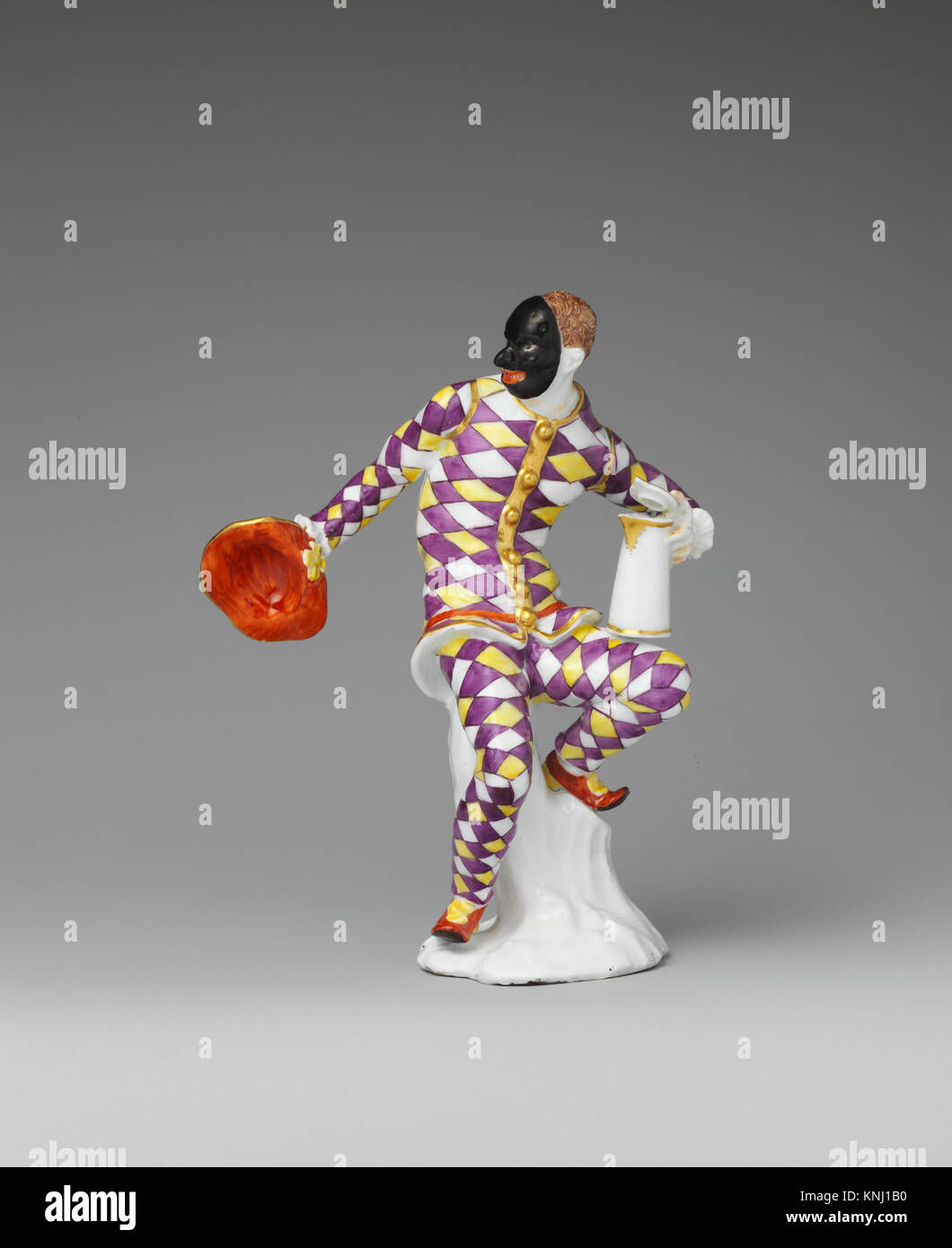Ein Kunstwerk aus dem 18. Jahrhundert, das einen Harlequin mit einem Krug zeigt und lebendige Farben, dynamische Posen und theatralische Kostüme in der Commedia dell'arte-Tradition hervorhebt. Stockfoto