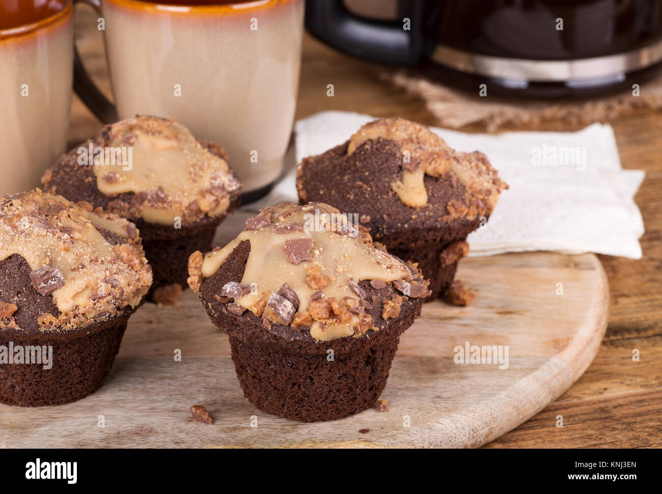 Peanut Butter Chocolate Cupcakes mit Zuckerglasur und Chips Stockfoto