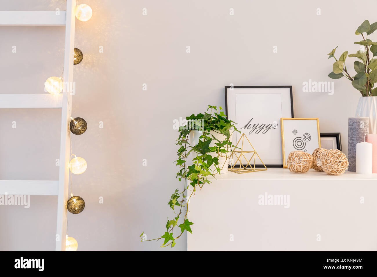 Home Interior im skandinavischen Stil mit weißen Schrank, Leiter und LED-Kugeln Stockfoto