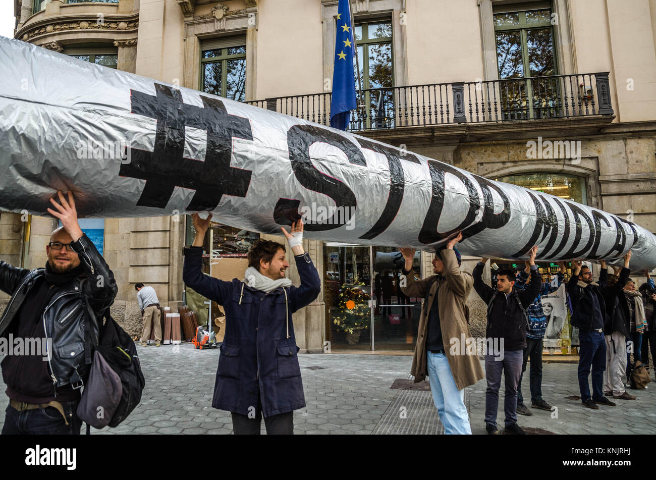 Barcelona, Katalonien, Spanien. 12 Dez, 2017. Mehrere Aktivisten gesehen zeigt ein aufblasbarer Globus mit dem Text "TOP MIDCAT'' eine katalanische Gas Pipeline. Zeitgleich mit dem Gipfel in Paris, einem Planeten, von Emmanuel Längestrich, eine kleine Gruppe von Aktivisten organisiert außerhalb der Hauptsitz der Europäischen Union in Barcelona konzentriert worden, und die Aufgabe von Beteiligungen an nicht-nachhaltige Energie zu verlangen. Zusammen mit der Weltbank (WB), andere Finanzinstitutionen und Fonds haben auf dem Gipfel einen Planeten angekündigt, dass sie sich nicht finanzieren, außer in der außergewöhnlichen Situation der Stockfoto