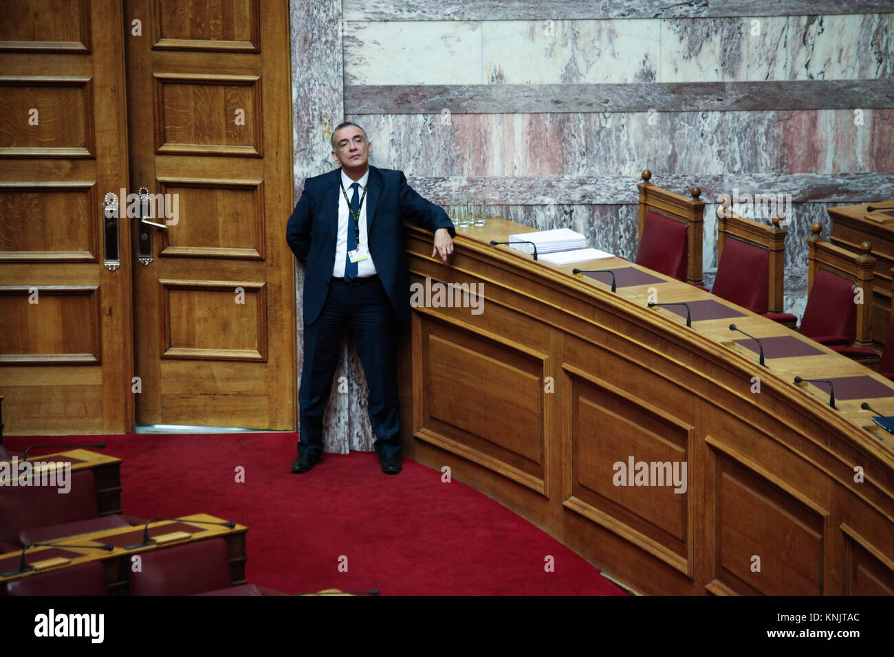 Athen, Griechenland. 12 Dez, 2017. Ein Mitarbeiter des griechischen Parlaments, offensichtlich müde, neben einer der Türen der Vollversammlung. Am ersten Tag der Haushaltsdebatte im griechischen Parlament. Die Regierung von Syriza und Anel vorhanden, was sie als die "letzte, welche in Zeiten der Vereinbarung zu fördern". Credit: Ioannis Mantas/Alamy leben Nachrichten Stockfoto