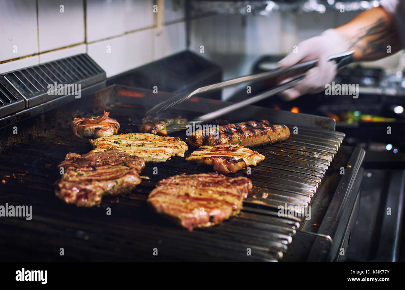 Koch Hände kochen verschiedene Fleisch auf dem Grill im Restaurant Küche Stockfoto