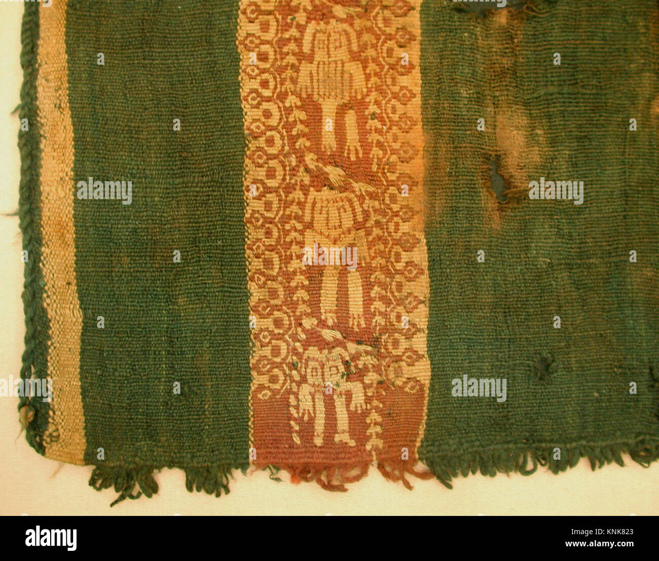 Diese ägyptische Tunika für Kinder mit Kapuze, datiert von 600 bis 900, besteht aus violetter, rotbrauner und grüner Wolle mit Fransen an der Kapuze und den unteren Kanten. Stockfoto