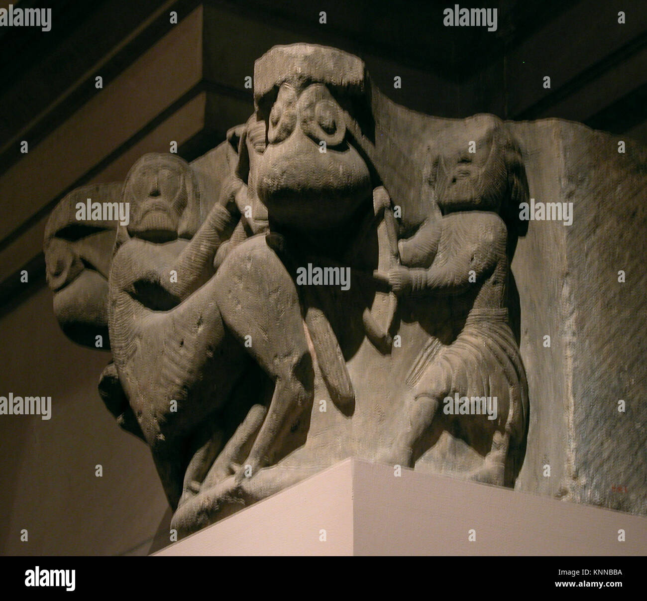 Diese Hauptstadt zeigt einen Zentauren, der mit Bogen und Pfeil gegen einen Mann kämpft, und veranschaulicht skulpturale Details und mythologische Ikonographie in historischer Architektur. Stockfoto